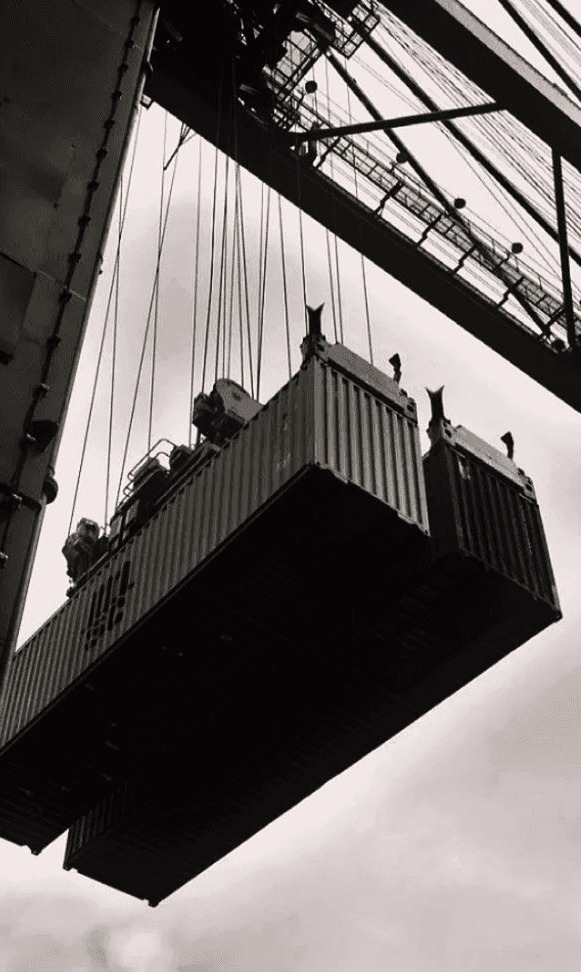 Shipping containers lifted by gantry crane